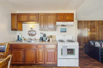 a kitchen with wooden cabinets and a white stove top oven at Meadow-Front Metcalf Bay Gem #542 in Big Bear Lake