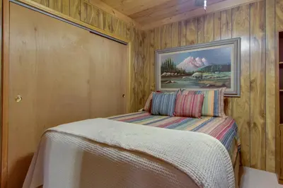 a bedroom with a bed with a painting on the wall at Castle Rock Cabin #2 in Big Bear Lake