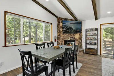 a dining room with a table and chairs and a fireplace at The Fox Den #2568 in Big Bear City