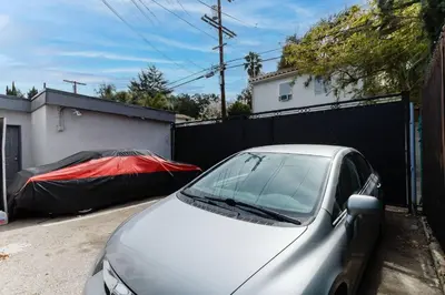 a silver car parked in a driveway next to a fence at Cozy Studio Studio City Unit 6 in Los Angeles