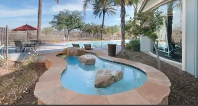 a swimming pool with rocks in the middle of a yard at Magic Splash Getaway in Santa Clarita