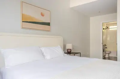 a bedroom with a white bed and a painting on the wall at Blueground Sawtelle view nr Westwood Park LAX-1396 in Los Angeles