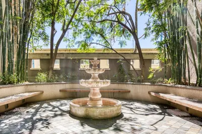a fountain in the middle of a courtyard with trees at Blueground Sawtelle view nr Westwood Park LAX-1396 in Los Angeles