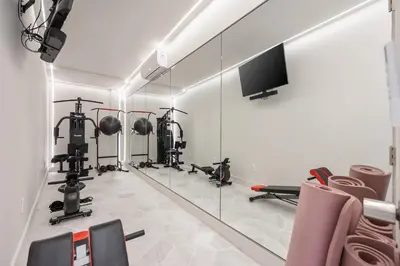 a gym with several tread machines and a mirror at Villa Avra by Stay Awhile Villas in Los Angeles
