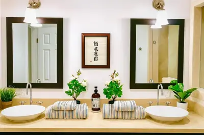 two sinks in a bathroom with two mirrors at Hollywood Hills Spa Retreat Oasis with Tree Top Views, Private Jacuzzi Style Tub, Steam Room, Magical Half Acre Acre Garden and Patio, Free Parking for 2 cars, in LA's most Serene, Central Desirable Area in Los Angeles
