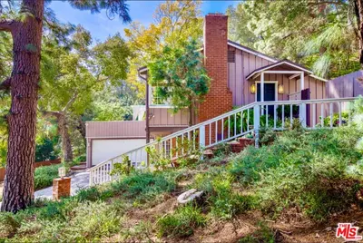 a pink house with a white porch and stairs at Hollywood Hills Spa Retreat Oasis with Tree Top Views, Private Jacuzzi Style Tub, Steam Room, Magical Half Acre Acre Garden and Patio, Free Parking for 2 cars, in LA's most Serene, Central Desirable Area in Los Angeles