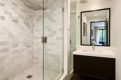 a bathroom with a sink and a glass shower at Chic Private Hollywood Hills Guest Suite Oasis with Tree-Top Views, Outdoor Living Room, Only 2 Minutes from Hollywood Boulevard in Los Angeles