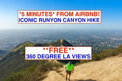 a man standing on top of a mountain with a sign at Chic Private Hollywood Hills Guest Suite Oasis with Tree-Top Views, Outdoor Living Room, Only 2 Minutes from Hollywood Boulevard in Los Angeles