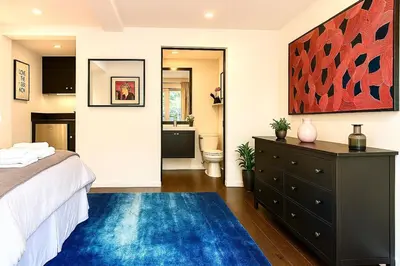 a bedroom with a bed and a blue rug at Chic Private Hollywood Hills Guest Suite Oasis with Tree-Top Views, Outdoor Living Room, Only 2 Minutes from Hollywood Boulevard in Los Angeles