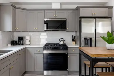 a kitchen with white cabinets and a stove top oven at Sunset Chateau Hollywood in Los Angeles
