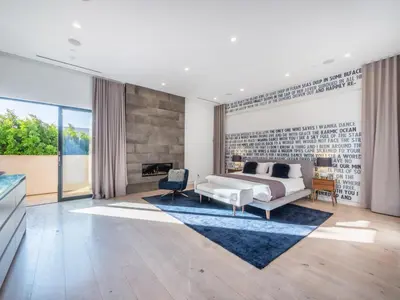 a living room with a bed and a fireplace at Sycamore Villa in Los Angeles