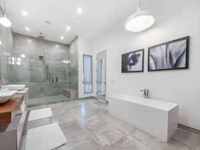 a bathroom with a tub and a shower and a sink at Sycamore Villa in Los Angeles