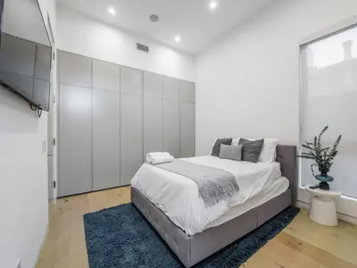 a bedroom with white walls and a large bed at Sycamore Villa in Los Angeles