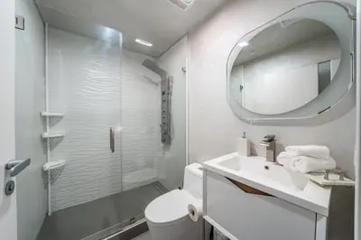 a bathroom with a shower and a sink and a mirror at Fulton Villa in Garnsey