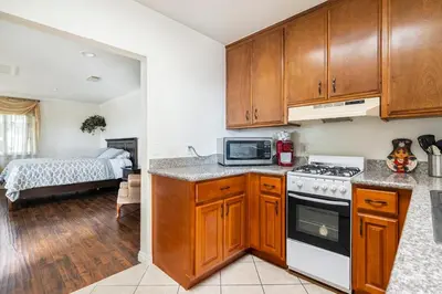 a kitchen with wooden cabinets and a stove top oven at King Studio with Self Check-In in Ontario