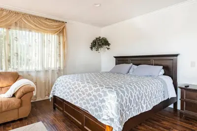 a bedroom with a large bed and a chair at King Studio with Self Check-In in Ontario