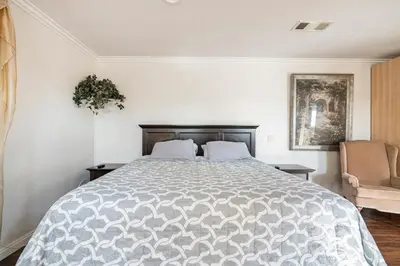 a bedroom with a large bed and a chair at King Studio with Self Check-In in Ontario