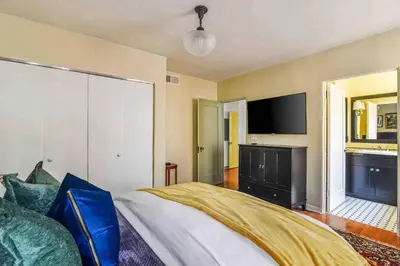 a bedroom with a bed and a flat screen tv at Welcome to The Spanish Hideaway! in Los Angeles