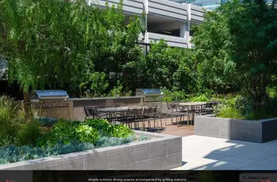 a patio with tables and chairs in a garden at Sky High at Beaudry 2 Bed Apt WITH FREE PARKING in Los Angeles