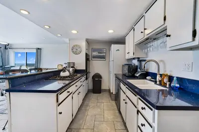 a kitchen with white cabinets and blue counter tops at Awesome On The Strand, Hermosa Beach Property in Hermosa Beach