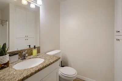 a white bathroom with a sink and a toilet at Top Floor Marina Escape 3BR Penthouse Ocean View in Los Angeles