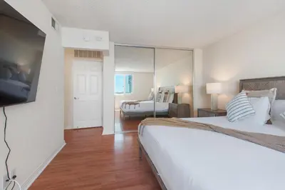 a bedroom with a large bed and a living room at Top Floor Marina Escape 3BR Penthouse Ocean View in Los Angeles