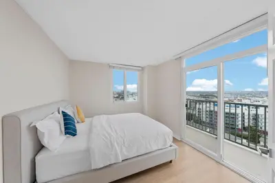 a white bedroom with a bed and a large window at Breezy & Beautiful - 3BR Marina del Rey Getaway in Los Angeles