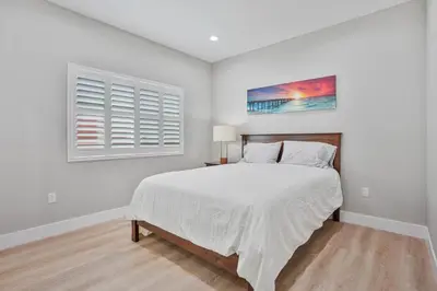 a white bedroom with a bed and a window at 2 Mi to Disneyland Home with Furnished Patio! in Anaheim