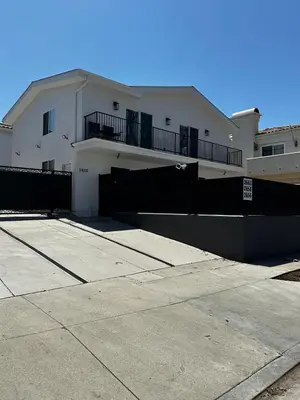 a white house with a black fence in front of it at cozy & Elegant Torrance Apartment with balcony in Torrance