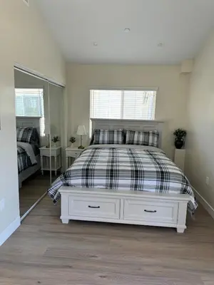 a bedroom with a bed with a black and white comforter at cozy & Elegant Torrance Apartment with balcony in Torrance