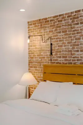 a bedroom with a brick wall and a bed at Hillside Guest House with Sunset View in Los Angeles