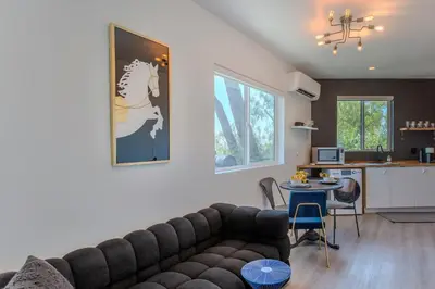 a living room with a couch and a kitchen at Hillside Guest House with Sunset View in Los Angeles