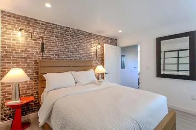 a bedroom with a bed and a brick wall at Hillside Guest House with Sunset View in Los Angeles
