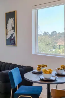 a table and chairs in a room with a window at Hillside Guest House with Sunset View in Los Angeles