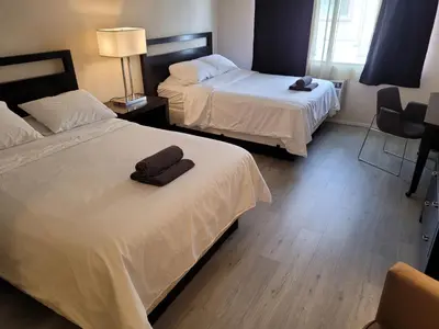 a hotel room with two beds and a chair at Beverly Hills Nest in Los Angeles