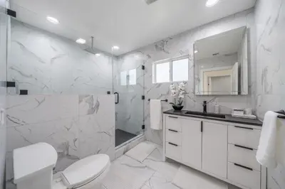 a white bathroom with a toilet and a shower at Bellaire in Garnsey