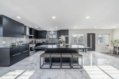 a kitchen with black cabinets and a table with benches at Bellaire in Garnsey