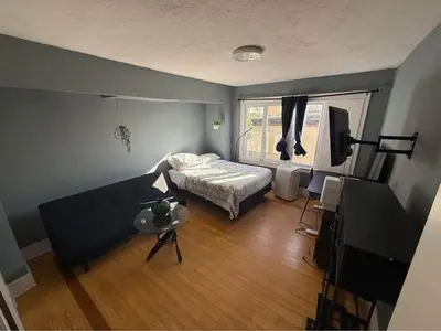 a bedroom with a bed and a couch and a television at Private Room in East Hollywood in Los Angeles