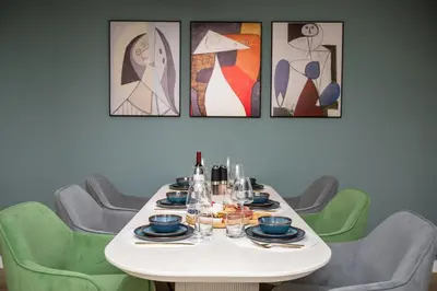 a table with plates and wine glasses on it with paintings at Ocean 2min, Romantic Bath, Cinema, Pool, Arcade in Marina del Rey