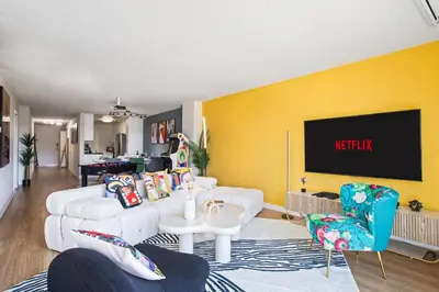 a living room with a white couch and a tv at Ocean 2min, Romantic Bath, Cinema, Pool, Arcade in Marina del Rey