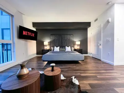 a bedroom with a bed and a sign on the wall at Modern Cosmopolitan APT Mid Hollywood with Free Parking 10mins to Universal Studios in Los Angeles