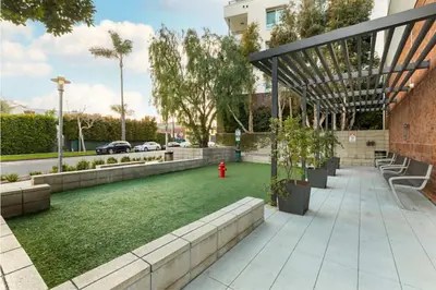 a garden with a red fire hydrant next to a building at Mid Century With Pool GYM and Parking 10min to Cedars in Los Angeles