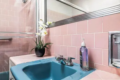 a bathroom with a blue sink and pink tiles at Spacious 4 bedroom home by Melrose and 10 minutes to Hollywood Walk of Fame in Los Angeles