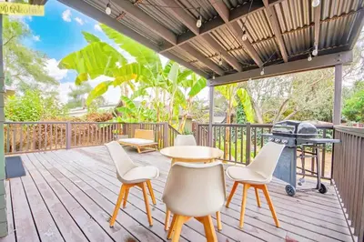 a deck with a table and chairs and a grill at Inviting 3BR Home with Porch & Greenery in Los Angeles
