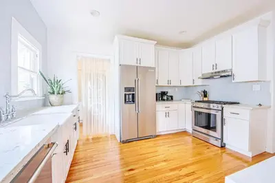 a kitchen with white cabinets and a stainless steel refrigerator at Inviting 3BR Home with Porch & Greenery in Los Angeles