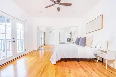a white bedroom with a bed and a ceiling fan at Inviting 3BR Home with Porch & Greenery in Los Angeles