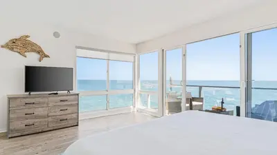 a bedroom with a large bed and a television at Beach Retreat with Oceanfront Balconies Direct Beach Access Pacific Coast Outlook by AvantStay in Malibu Beach