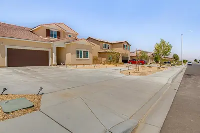 a driveway in front of a house with a garage at Cozy Desert Sanctuary 9 Mi to Mojave Narrows Park! in Victorville
