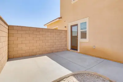 a building with a sidewalk next to a fence at Cozy Desert Sanctuary 9 Mi to Mojave Narrows Park! in Victorville