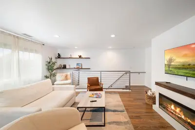 a living room with a white couch and a fireplace at Bay Breeze Hideaway in Lawndale